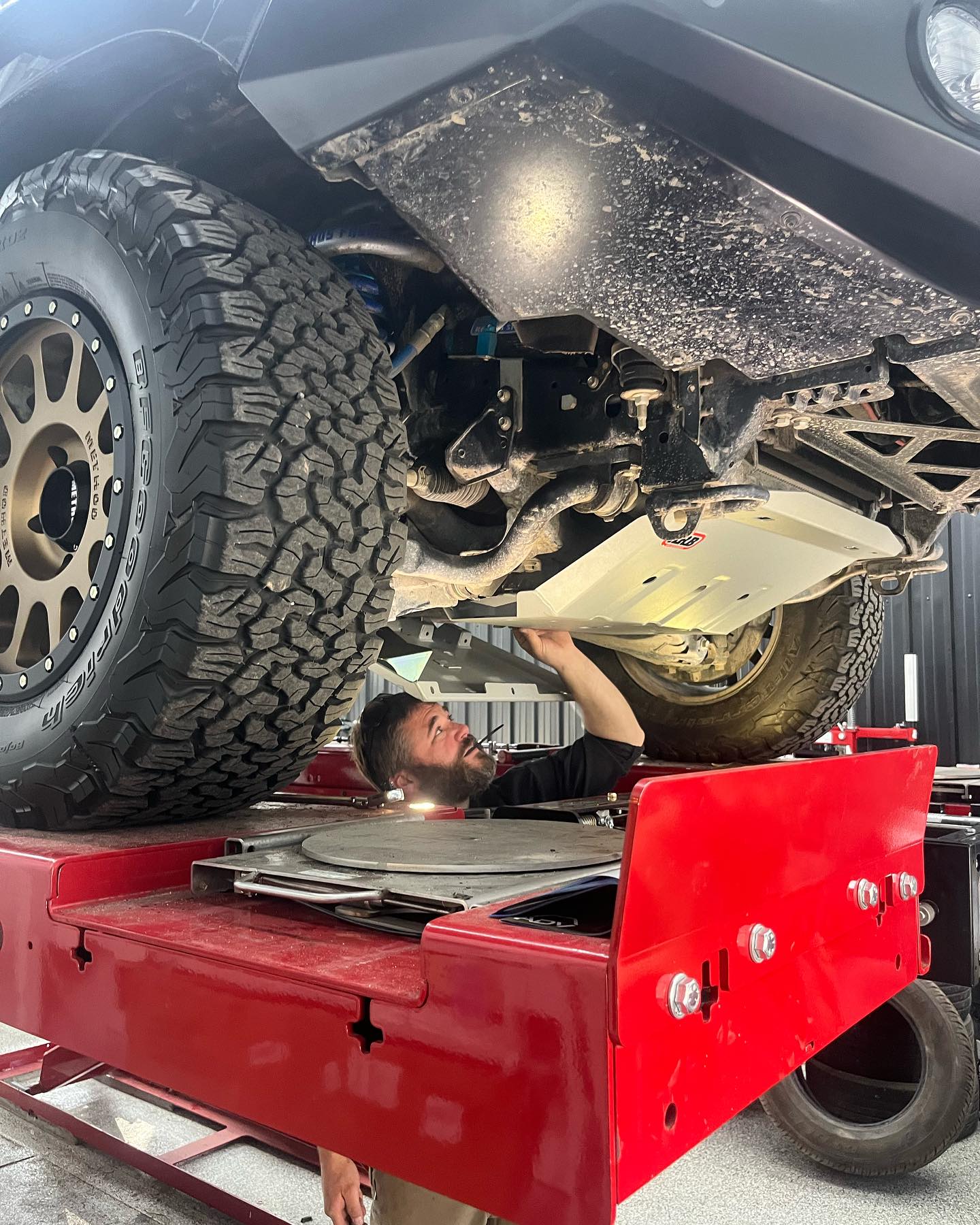 Technician on alignment rack working under vehicle