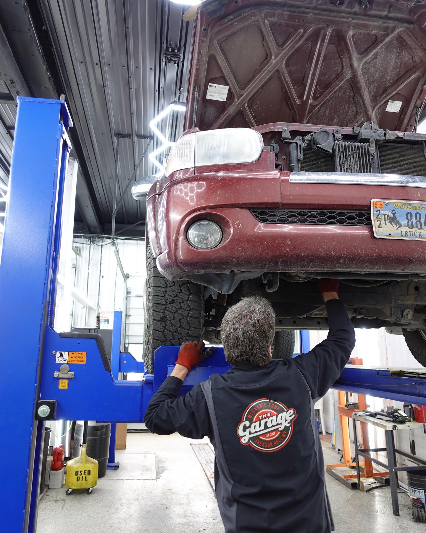 Mechanic inspecting undercarriage of lifted truck